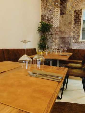 Un ristorante con tavoli, sedie e bicchieri sopra