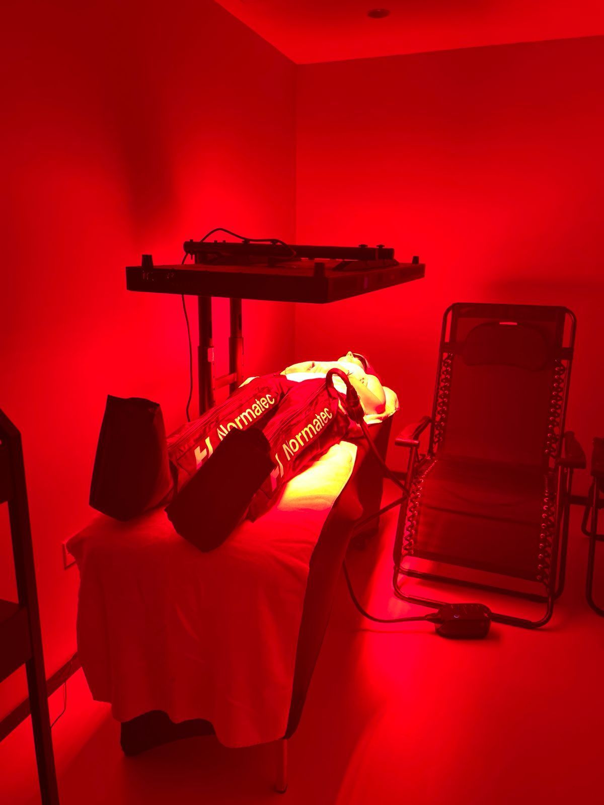 Red-lit room with a person on a massage table and a keyboard stand nearby