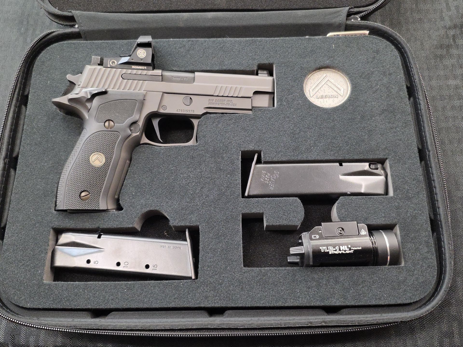 A silver-toned semi-automatic pistol engraved with 