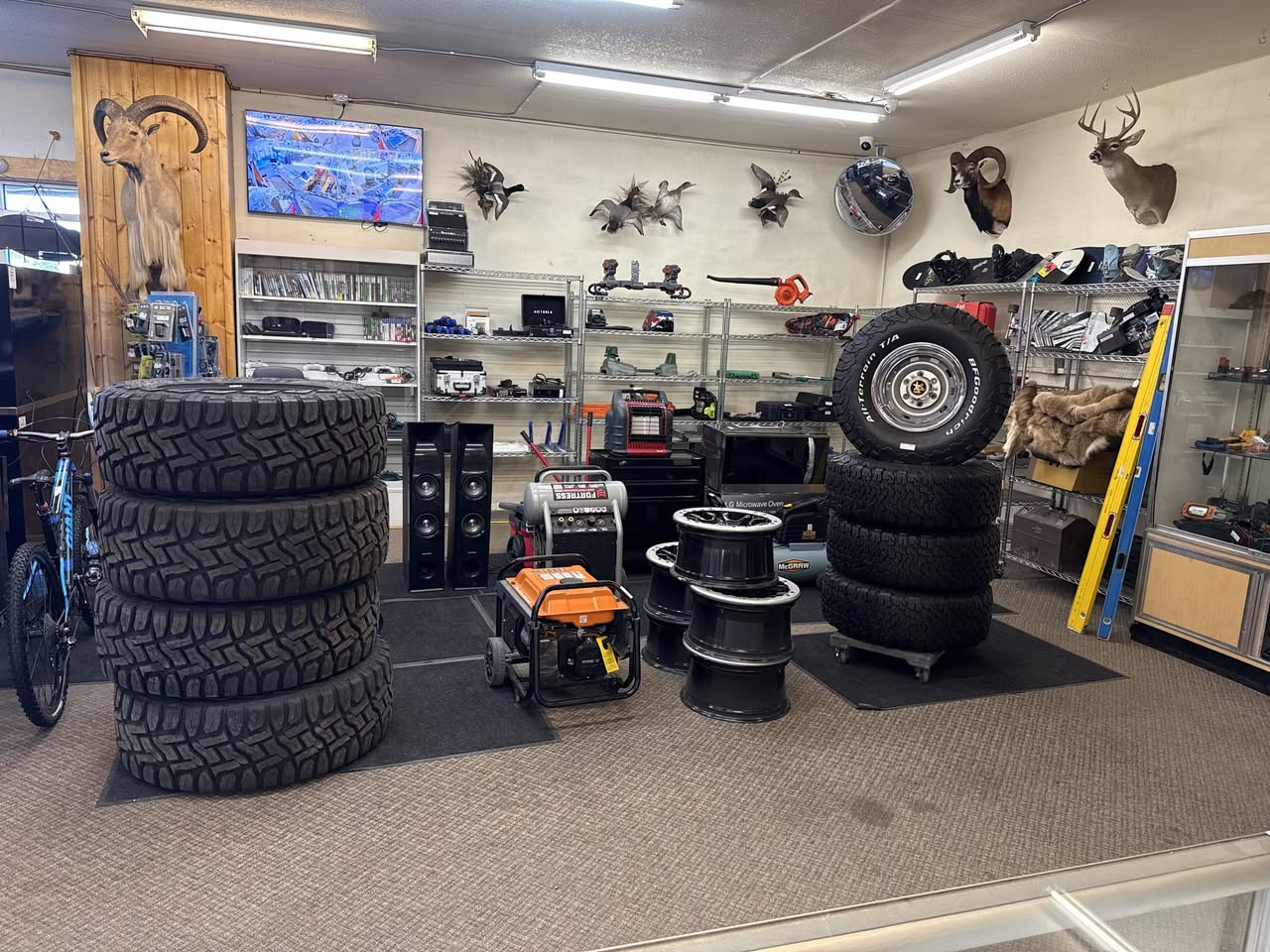 A room displaying tires, equipment, and mounted wildlife heads.