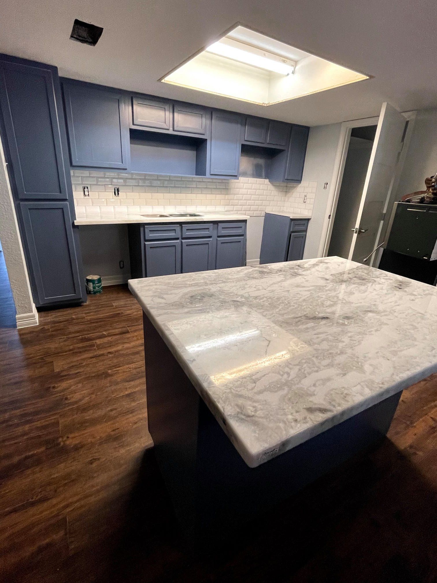 a kitchen with blue cabinets and a large white counter top .