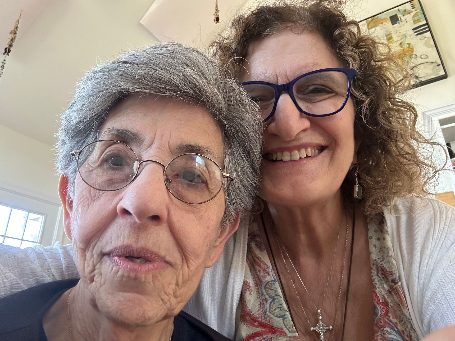 Two older women wearing glasses are posing for a picture together.