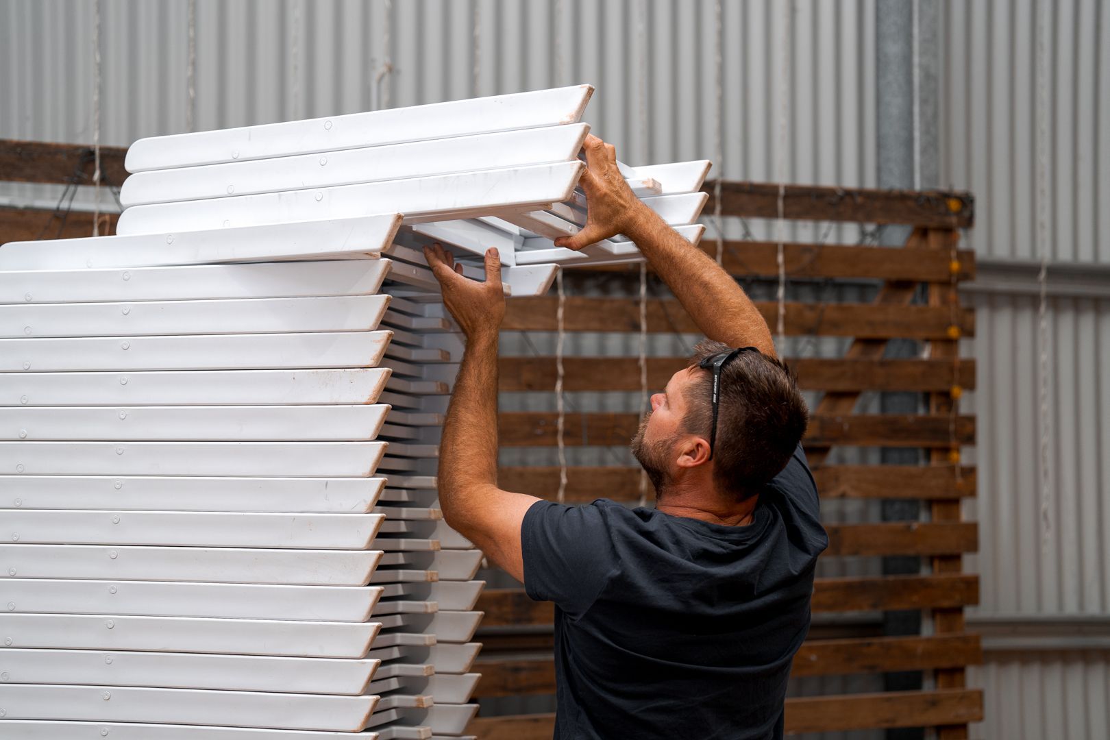 Man unstacking white chairs.