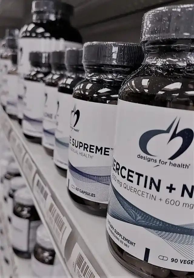 A row of bottles of ercetin + n on a shelf in a store