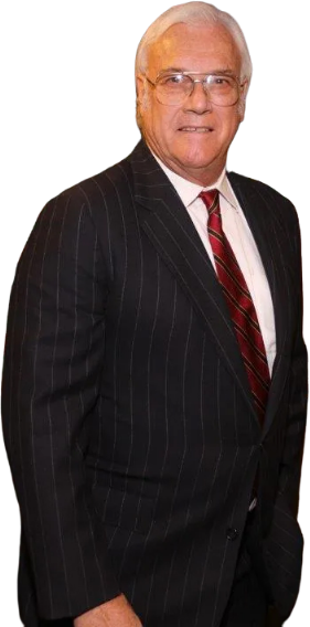 A man in a suit and tie is standing with his hands in his pockets. A man in a suit and tie is standing with his hands in his pockets.