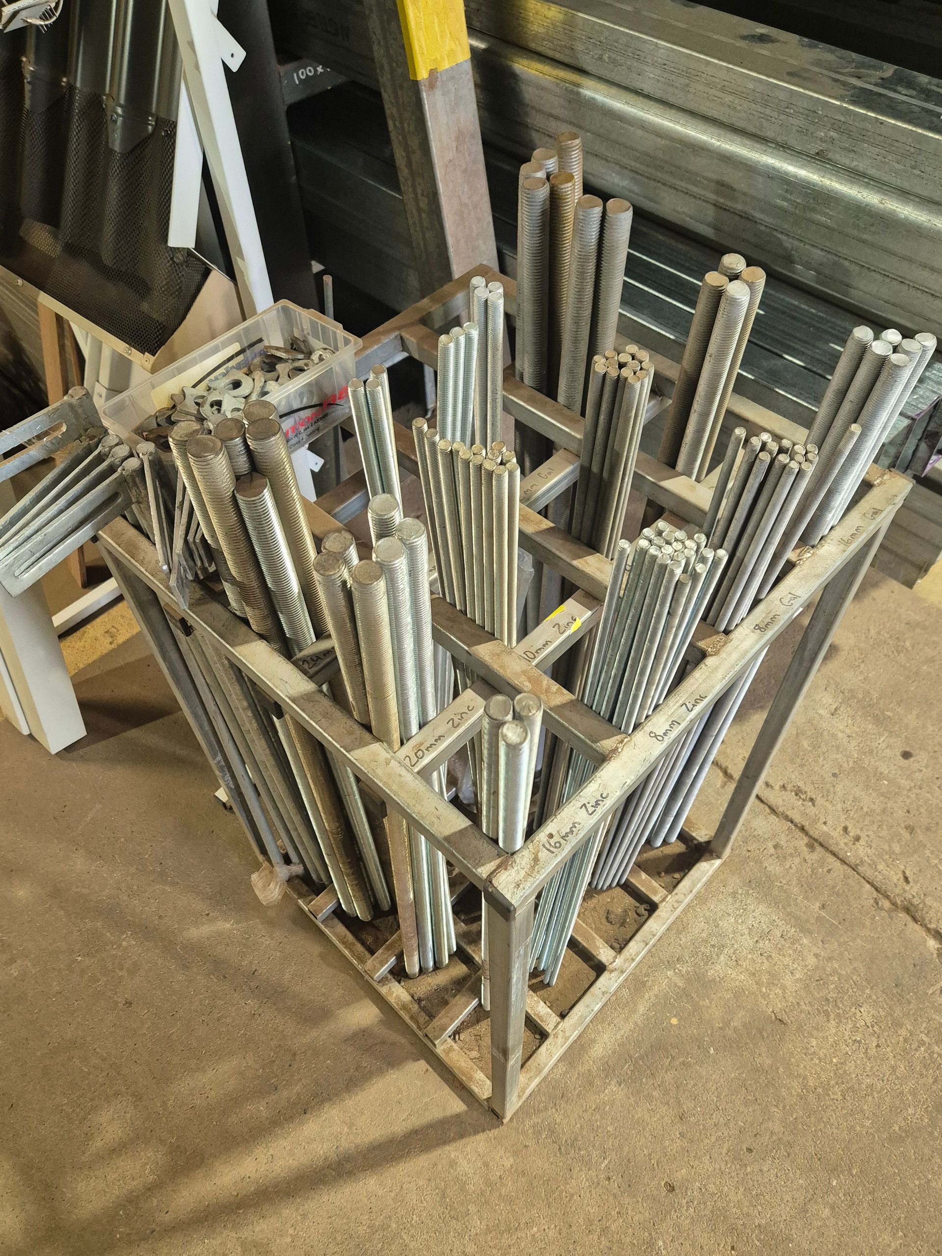 Metal rods bundled inside a wooden crate, in a cluttered workshop.