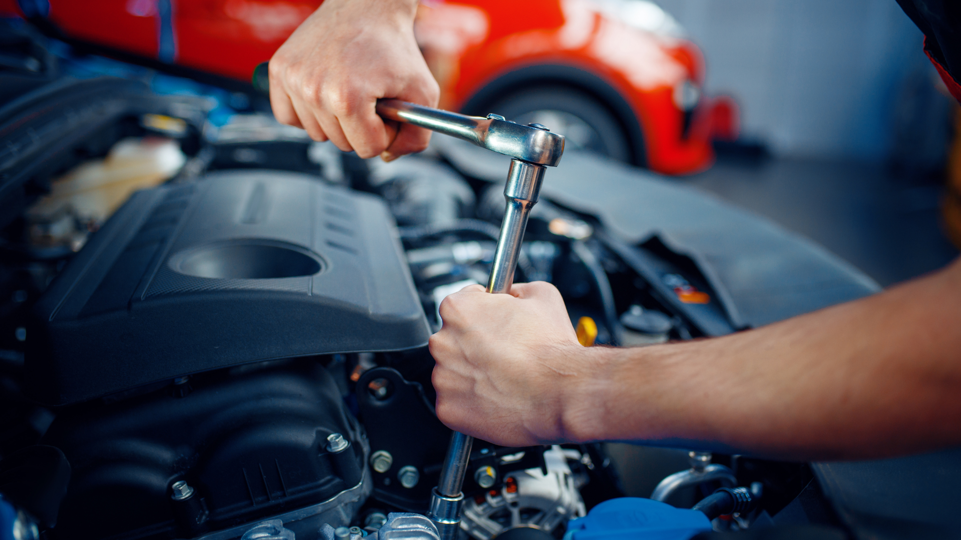 a man is working on the engine of a car with a wrench .