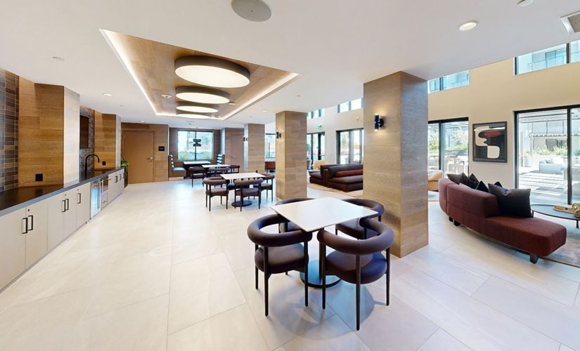 Interior common area with seating, tables, and a kitchenette in a modern apartment community at Sofia, offers pet-friendly apartments in Santa Clara.