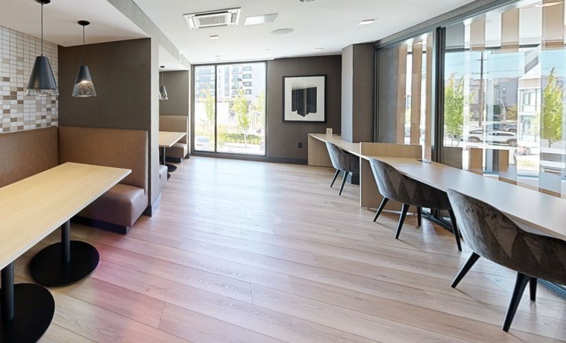 Bright modern resident lounge with booths, desks, and large windows at Sofia, offers pet-friendly apartments in Santa Clara.