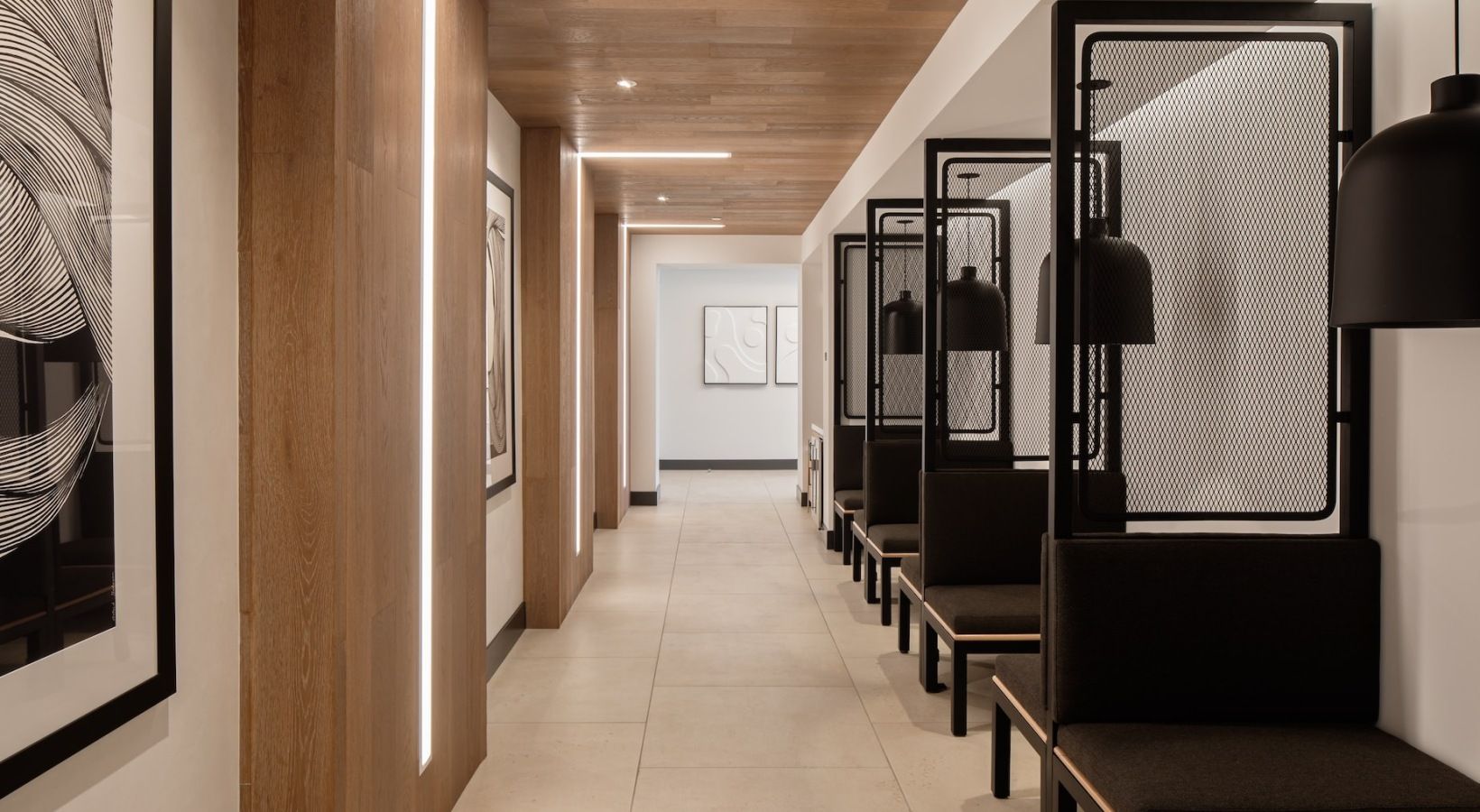 Modern interior corridor with wooden panels and seating pods along one side at Sofia, offers apartments for rent in Santa Clara, CA.