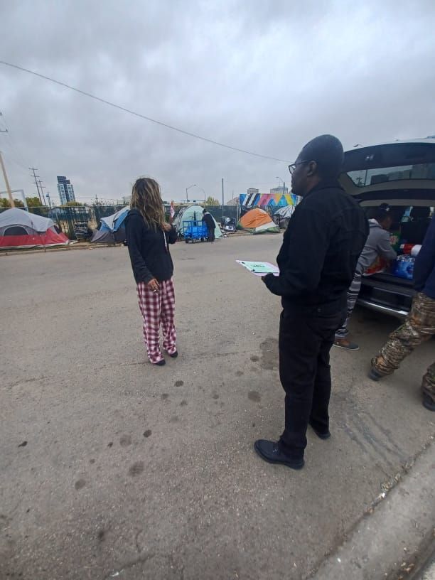 a man and a woman are standing next to each other in a parking lot .