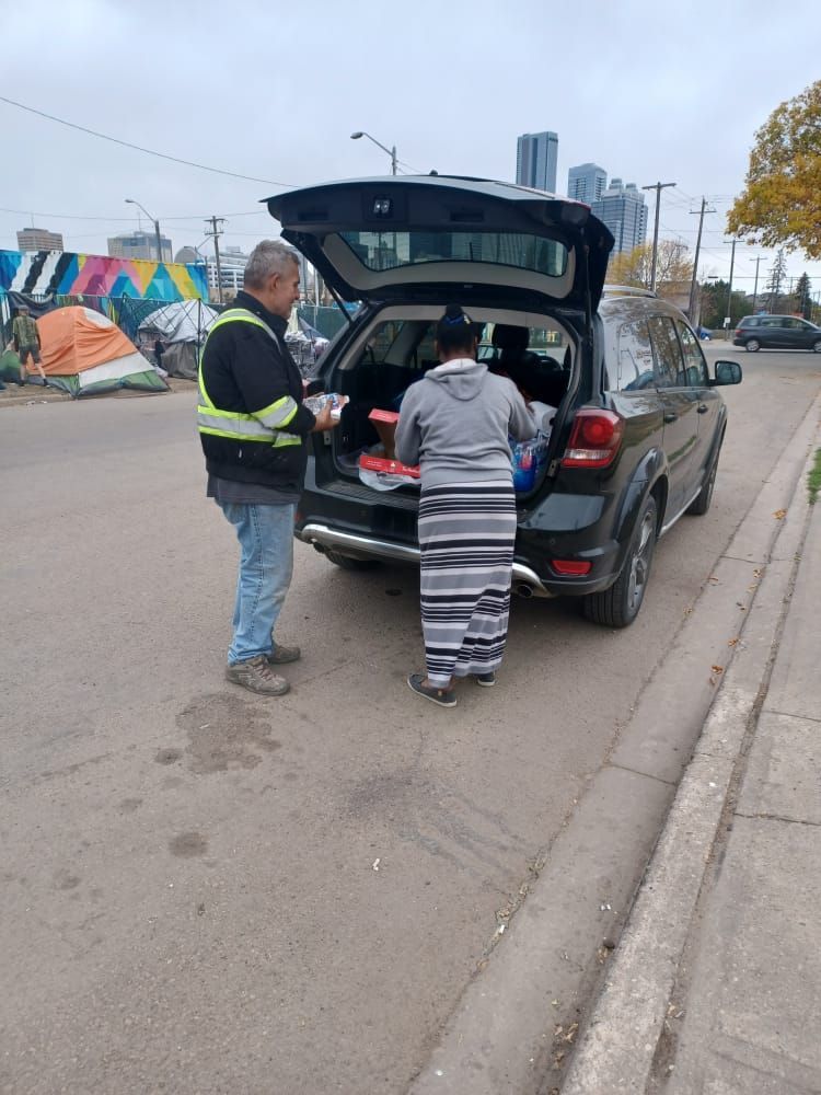 a man is standing next to a woman in the back of a car .