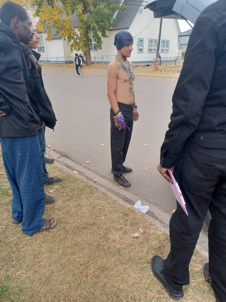 a group of men are standing on the side of the road