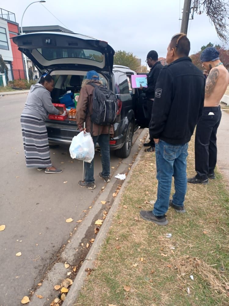 a group of people standing around a car with the trunk open