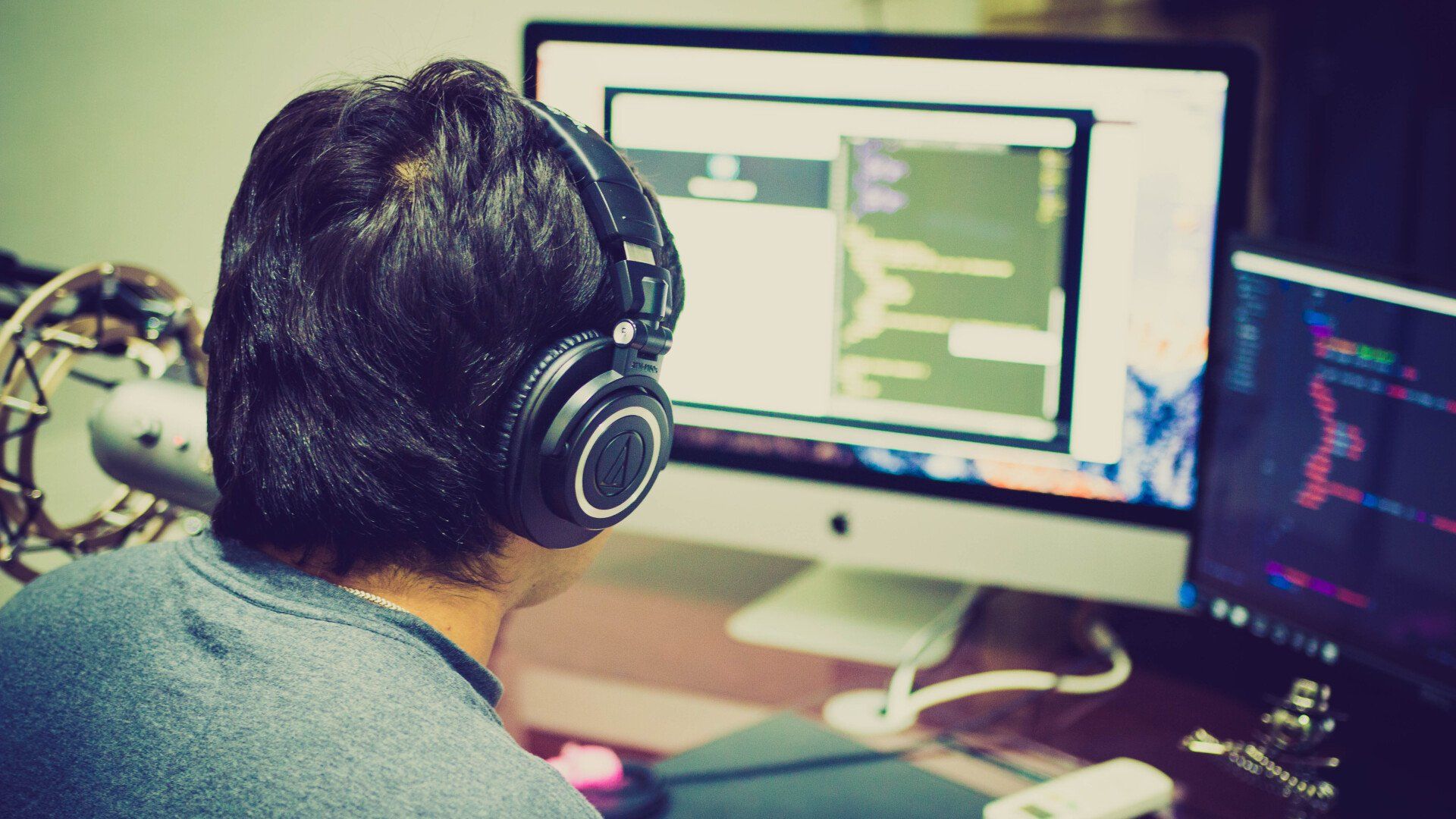 a man wearing headphones is sitting in front of a computer .