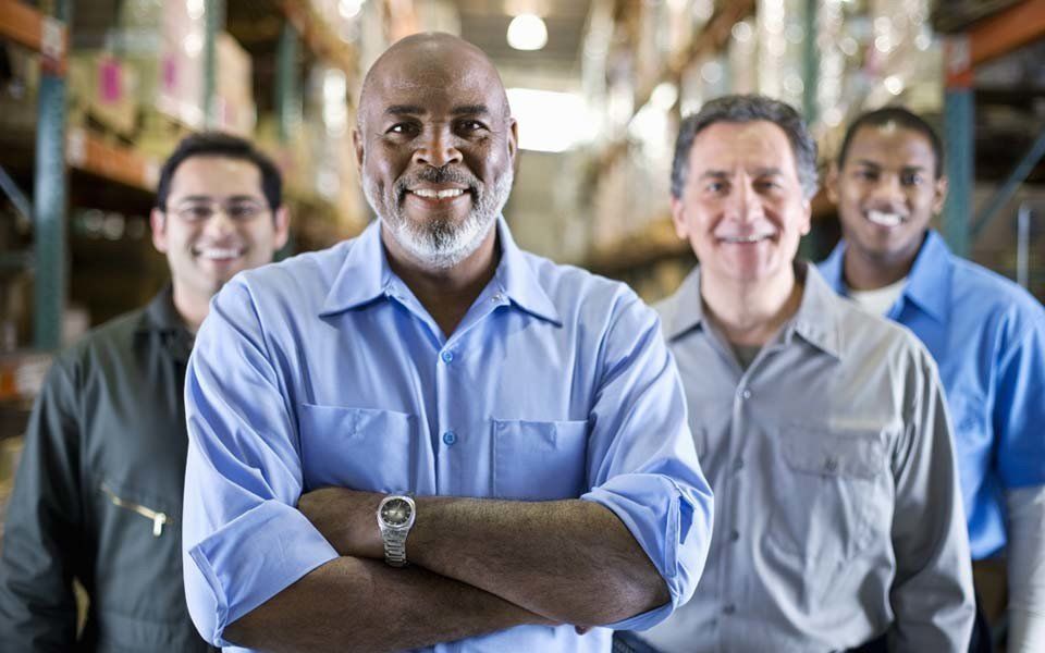 homens maduros sorriem de braços cruzados enquanto sorriem para a foto
