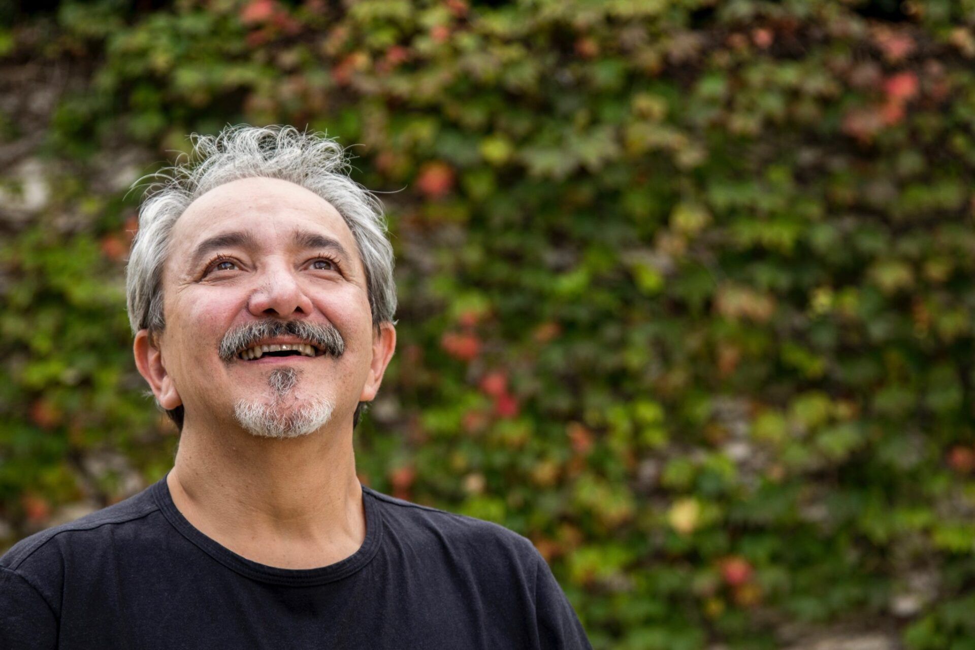 homem olha para cima e sorri em expressão de satisfação