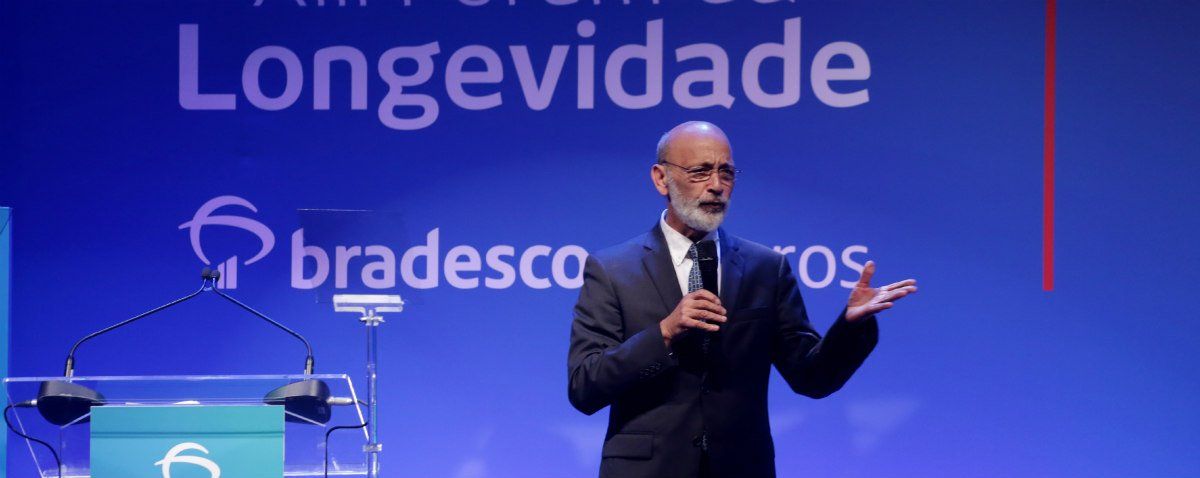 homem palestra vestindo terno preto enquanto segura microfone