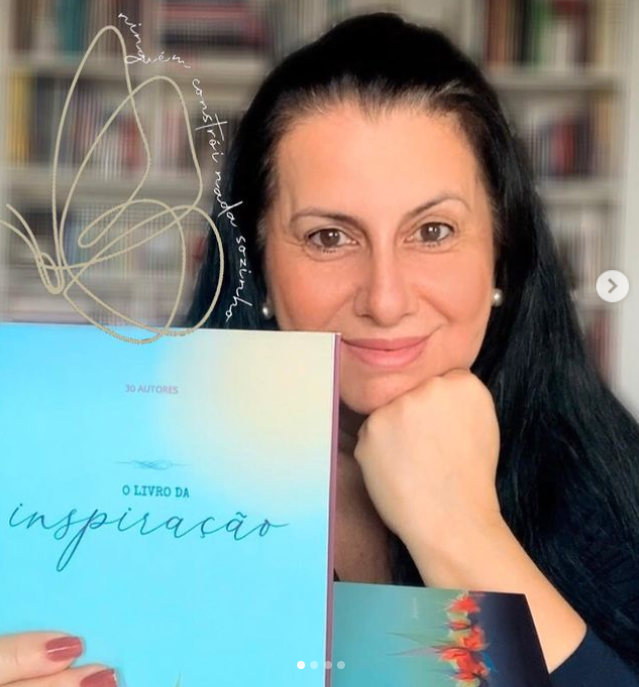 Claudia Mendonça, uma das autoras do livro,  segura o livro e posa para foto