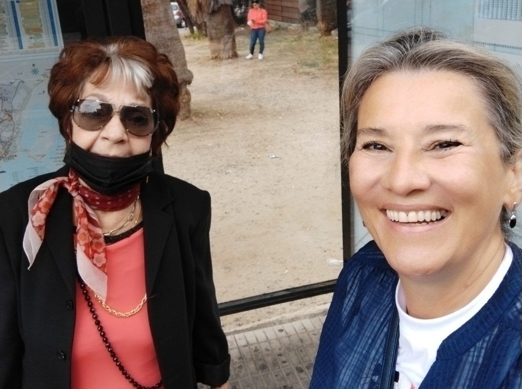 Super sênio posa ao lado da autora elegantemente, a maturi usa um lenço no pescoço, máscara e olhos escuros