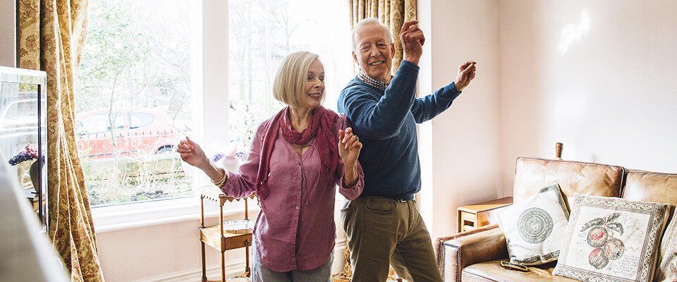 casal maduri dança, os dois se divertem enquanto sorriem no meio da sala