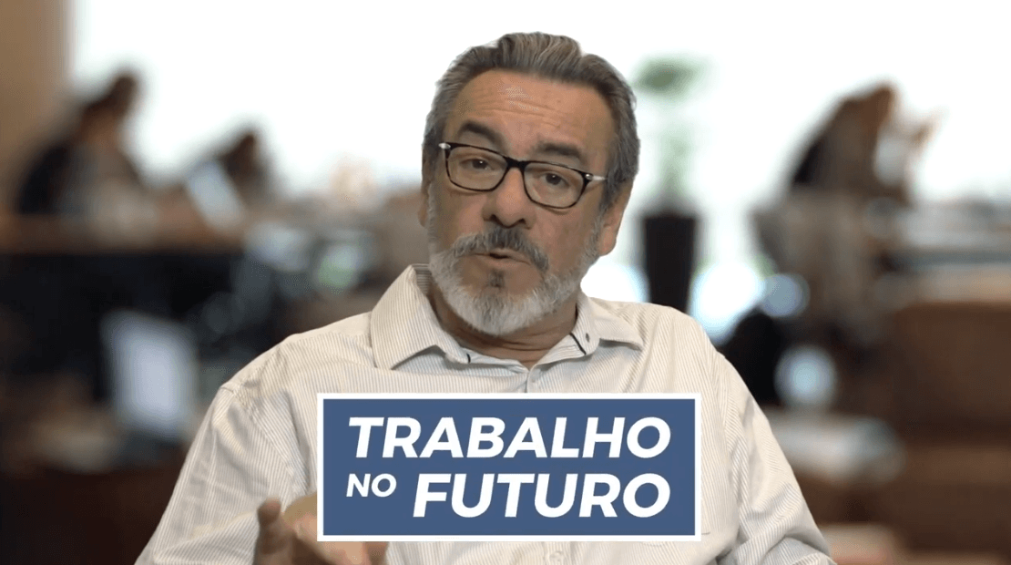 homem dando entrevista com camisas de botões branca e óculos com armação preta