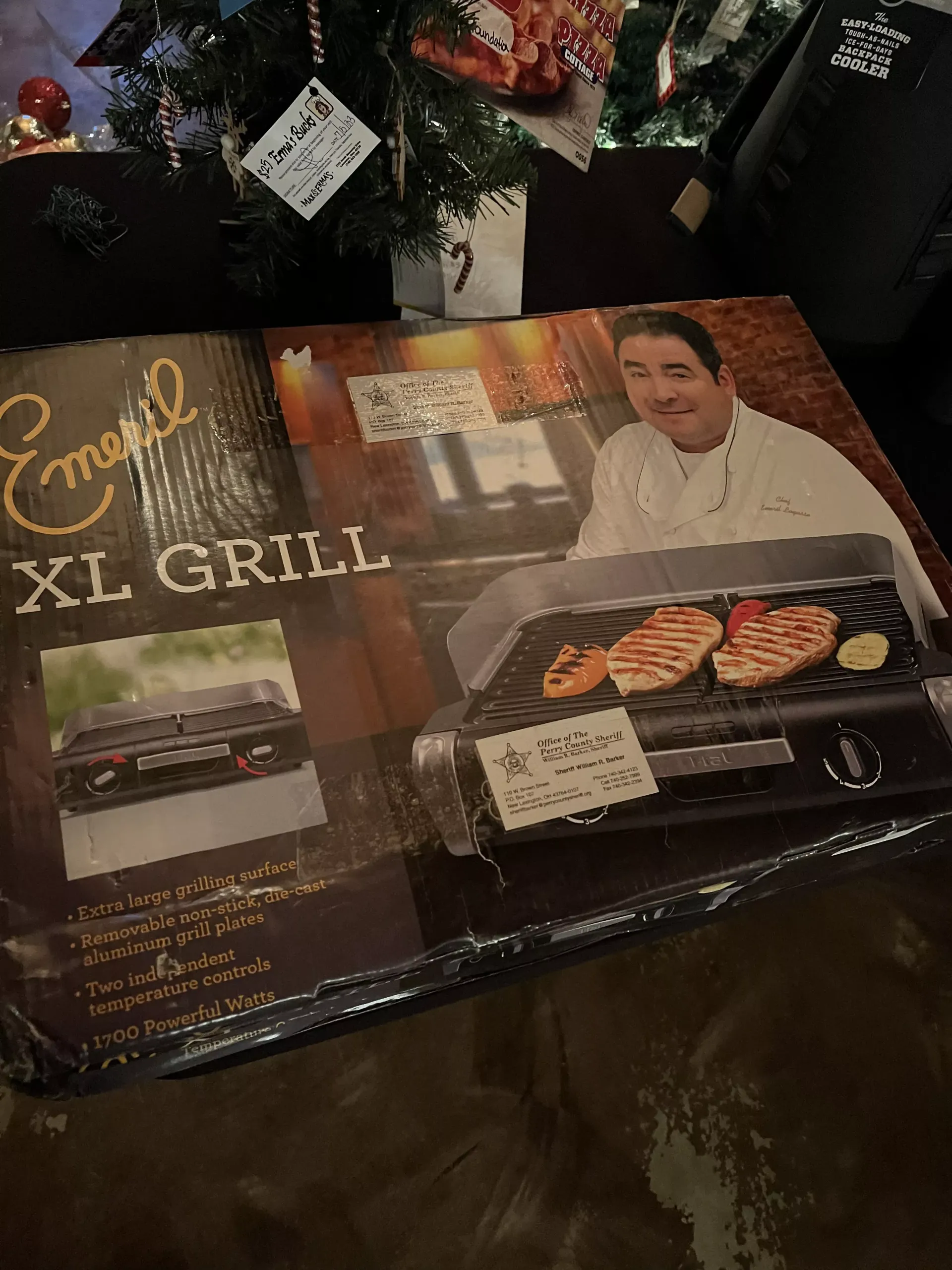 Cookbook titled “Easy XL Grill” beside a decorated Christmas tree on a dark wooden table.
