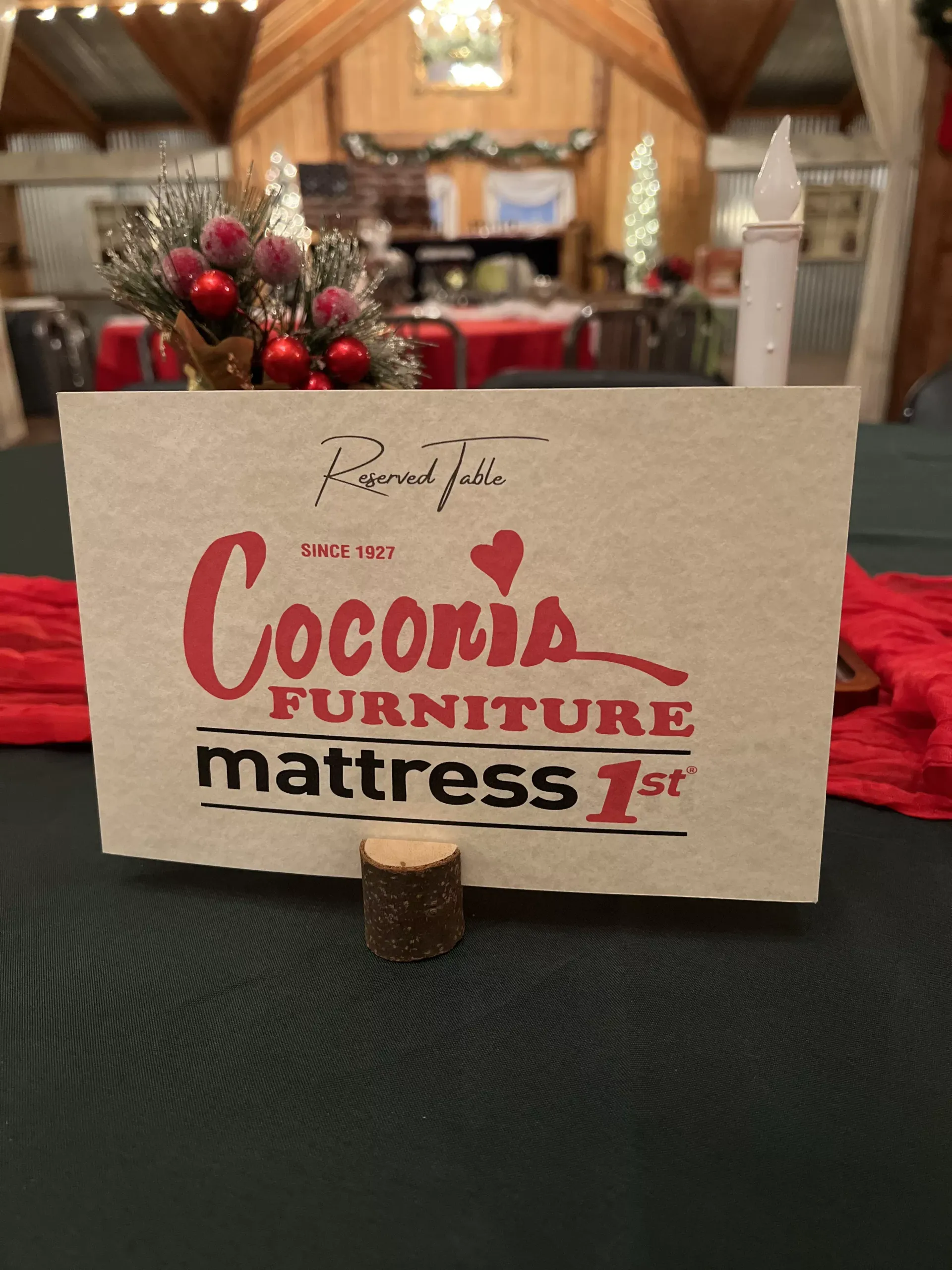 Cocoa furniture and mattress sign on a table in a cozy, wood-paneled room with red ornaments