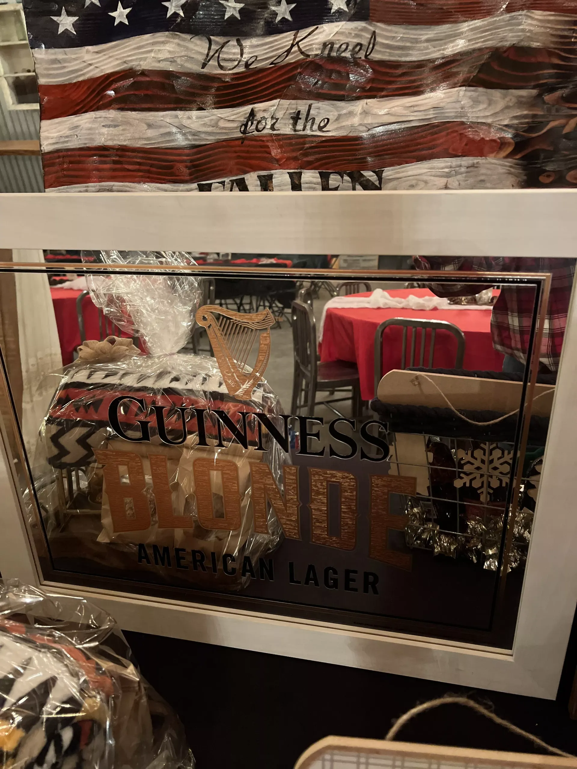 Guinness beer mirror sign with red draped tables reflected in a restaurant setting