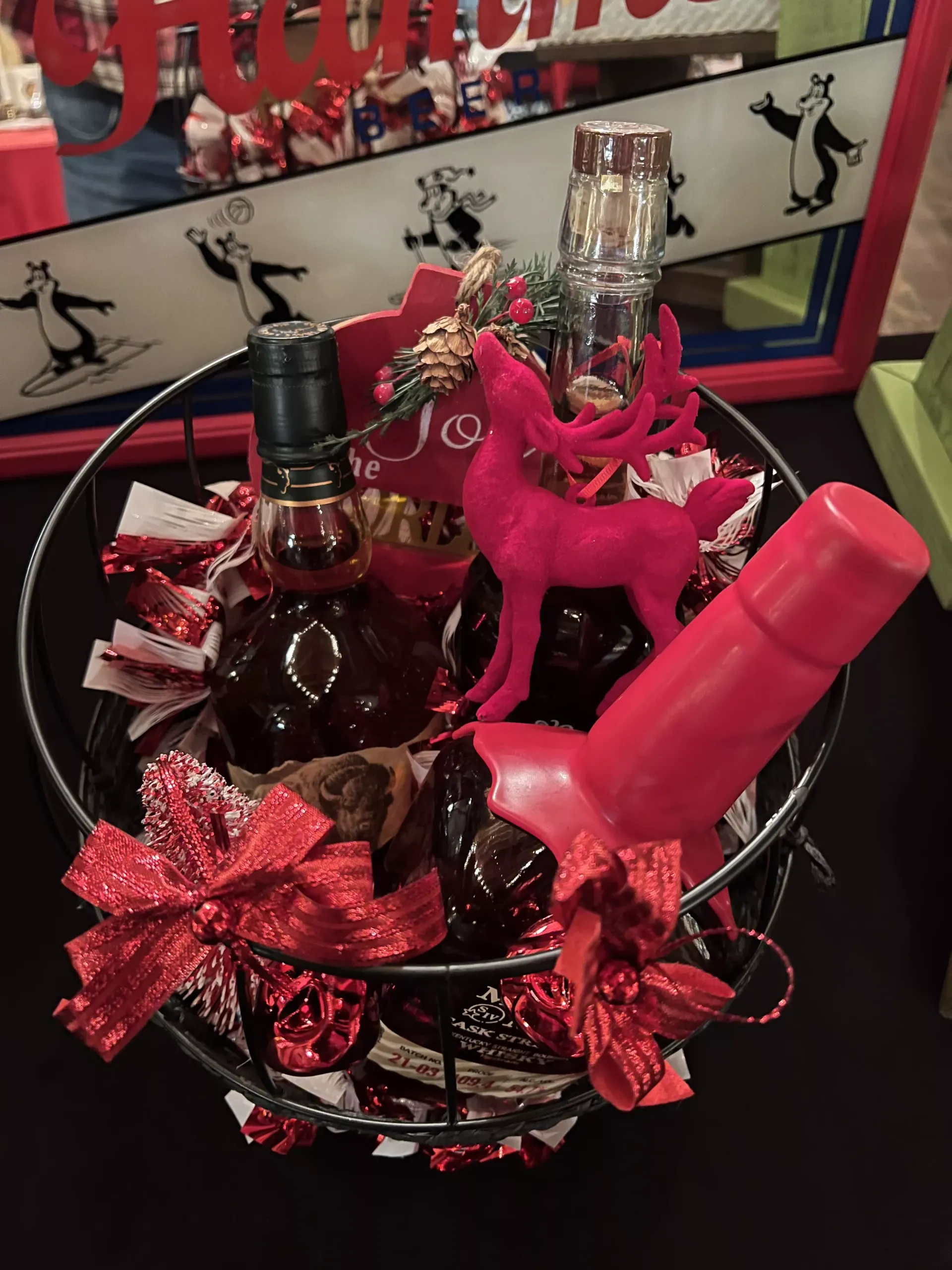 Pink-themed gift basket with champagne, a wine bottle, and a pink vibrator tied with red bows