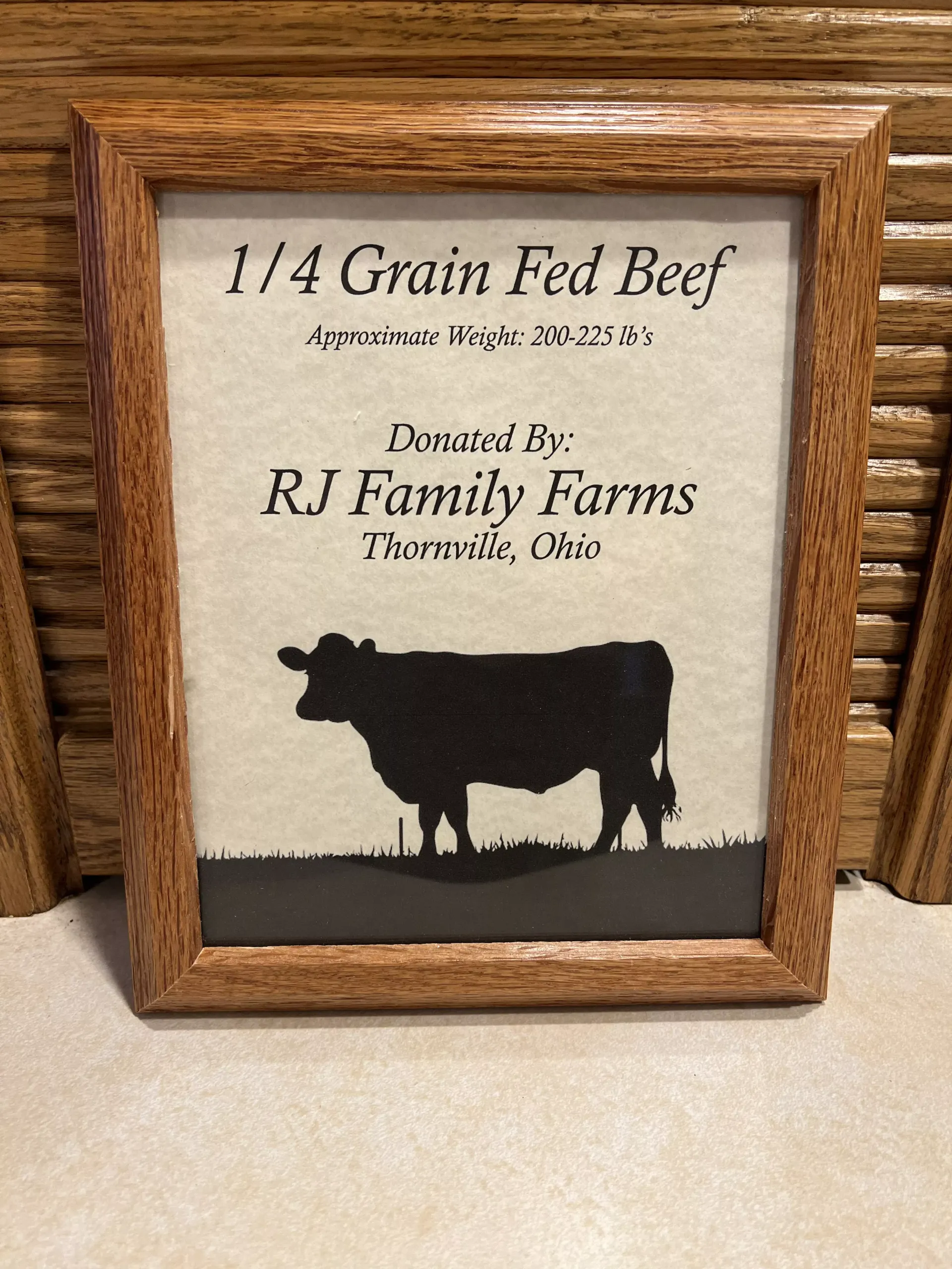 Framed sign for 1/4 grain-fed beef from RJ Family Farms in Tiffin, Ohio, with cow silhouette