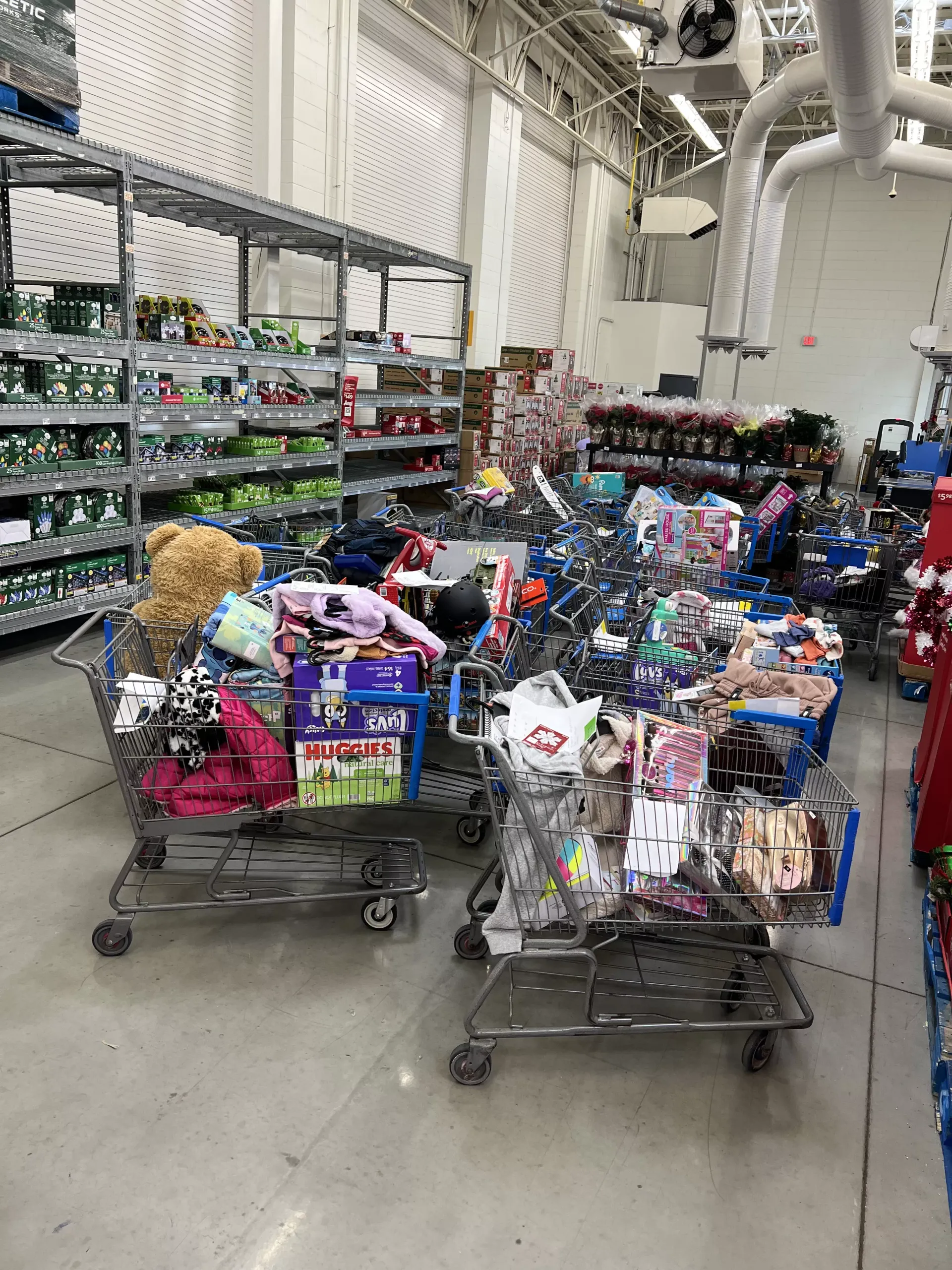 Shopping carts filled with colorful toys in a warehouse store aisle