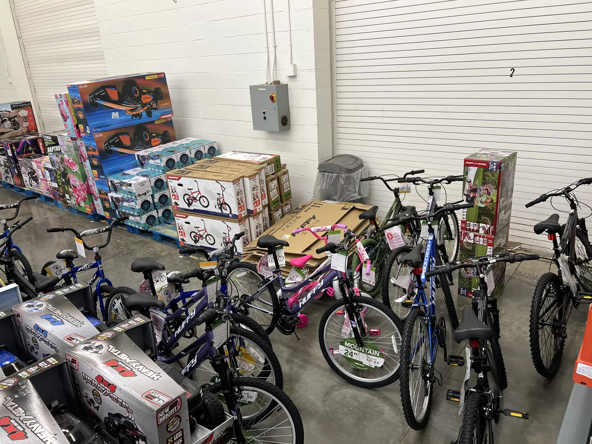 Bicycles piled in a store aisle beside stacked boxed merchandise.