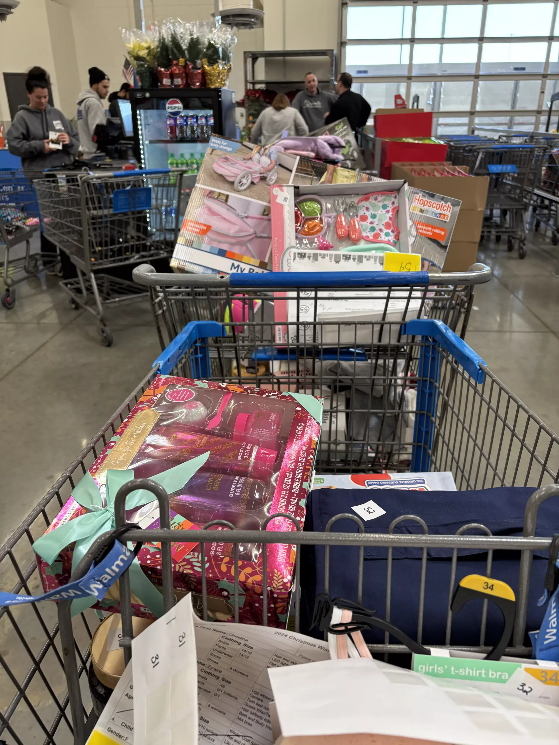 Shopping carts filled with gifts and groceries in a store checkout area