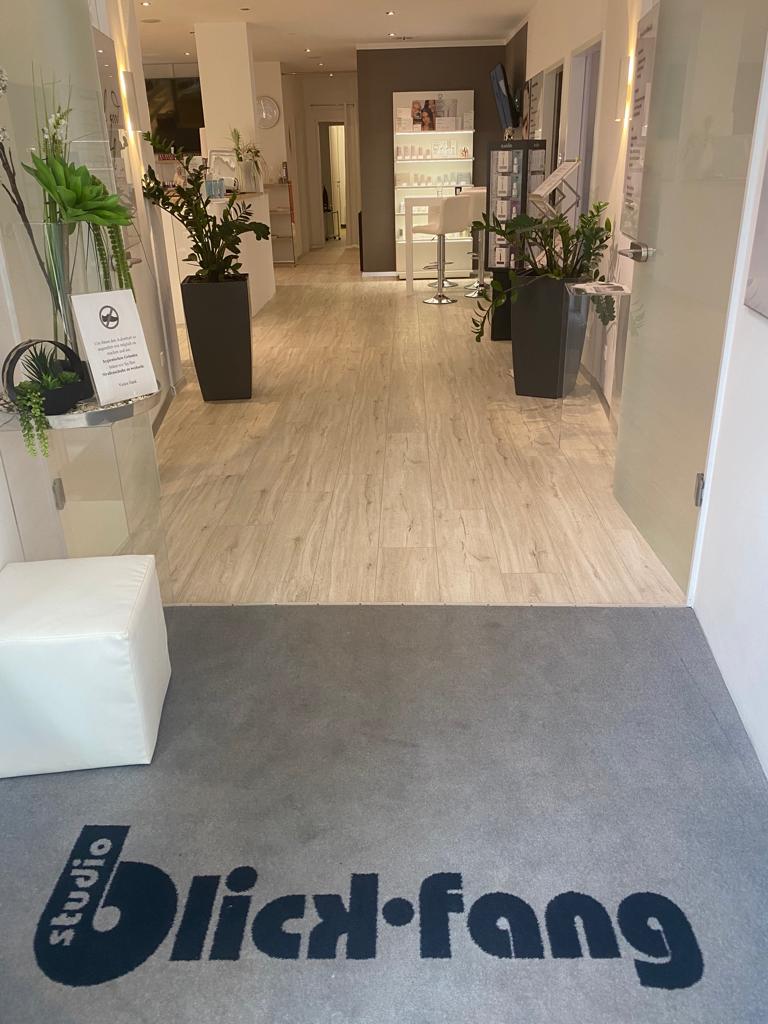 Ein Flur mit einem Teppich, auf dem „Blick-Fang“ steht