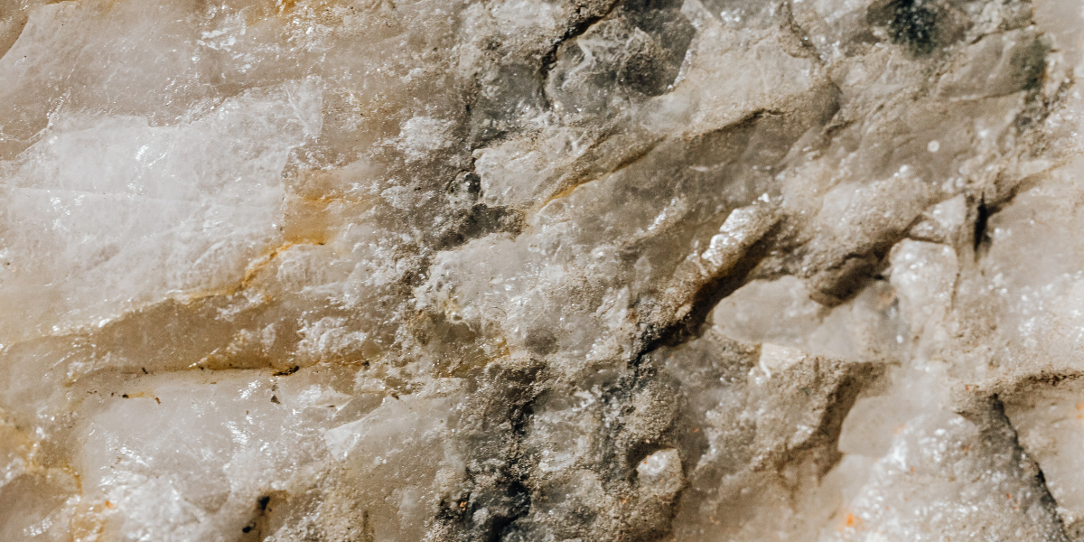 Close-up of white and tan marble with gray veining and rough texture