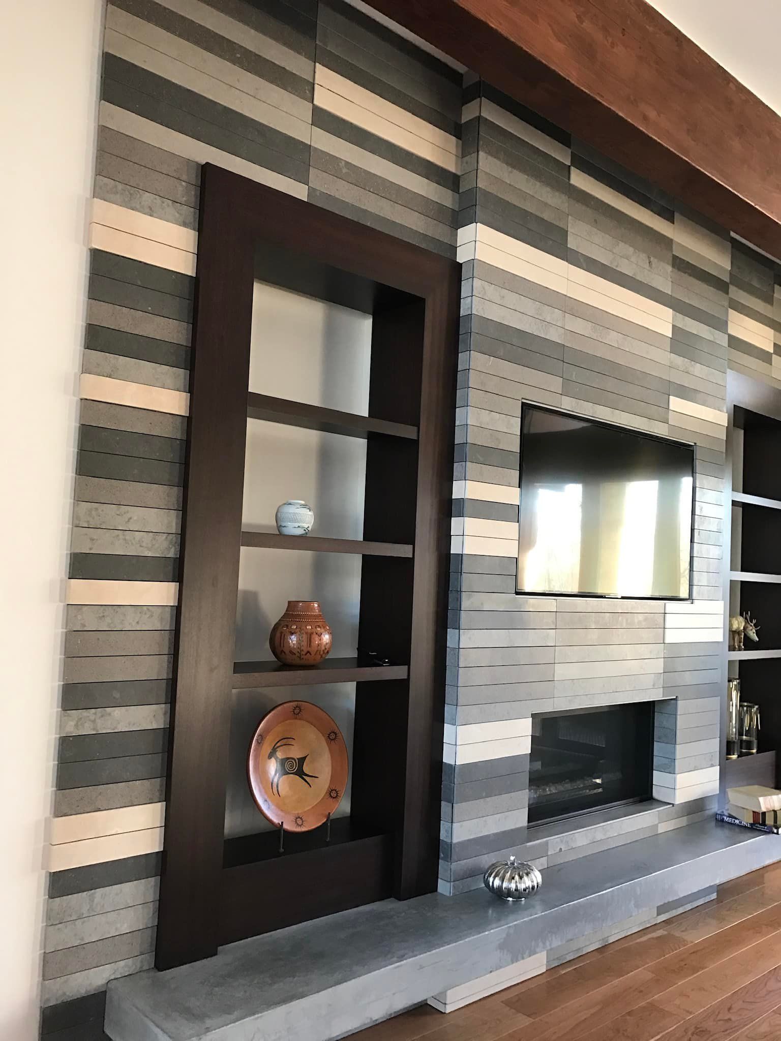 Modern living room wall with striped wallpaper, dark wood shelving, and decorative plates near a window.