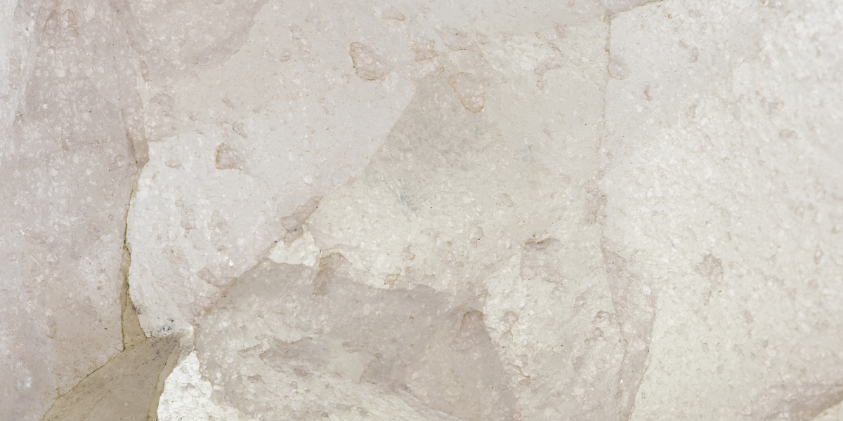 Close-up of pale, textured rock or stone surface with light beige and gray tones