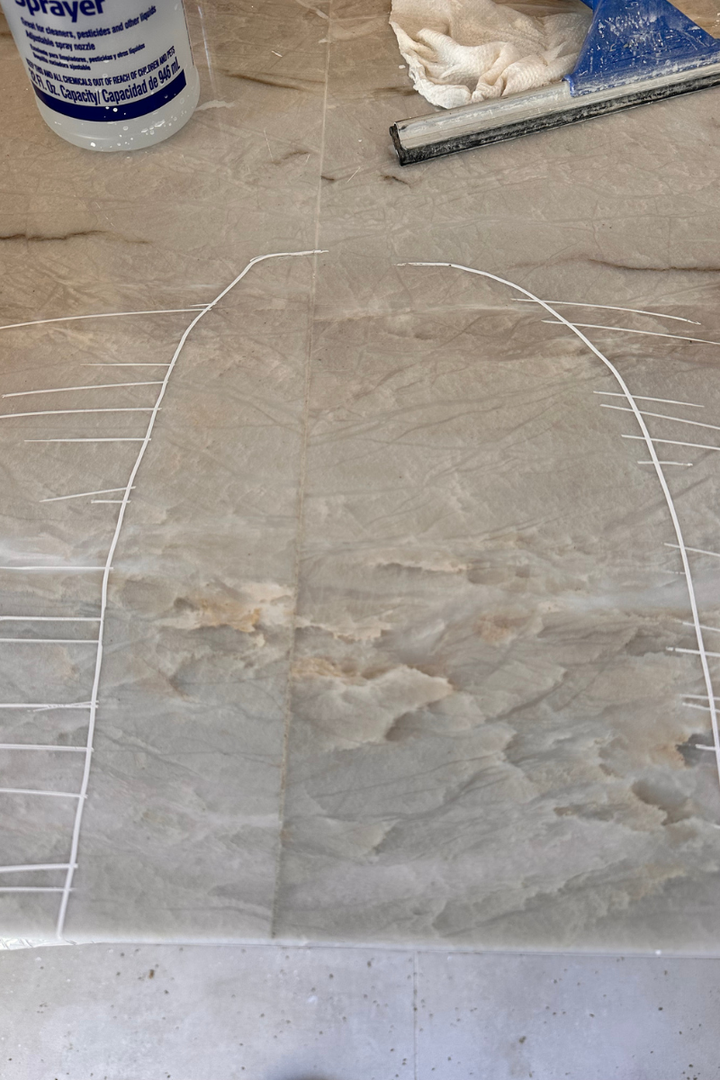 Dusty work surface with a chalk outline of a shape and scattered tools in the background