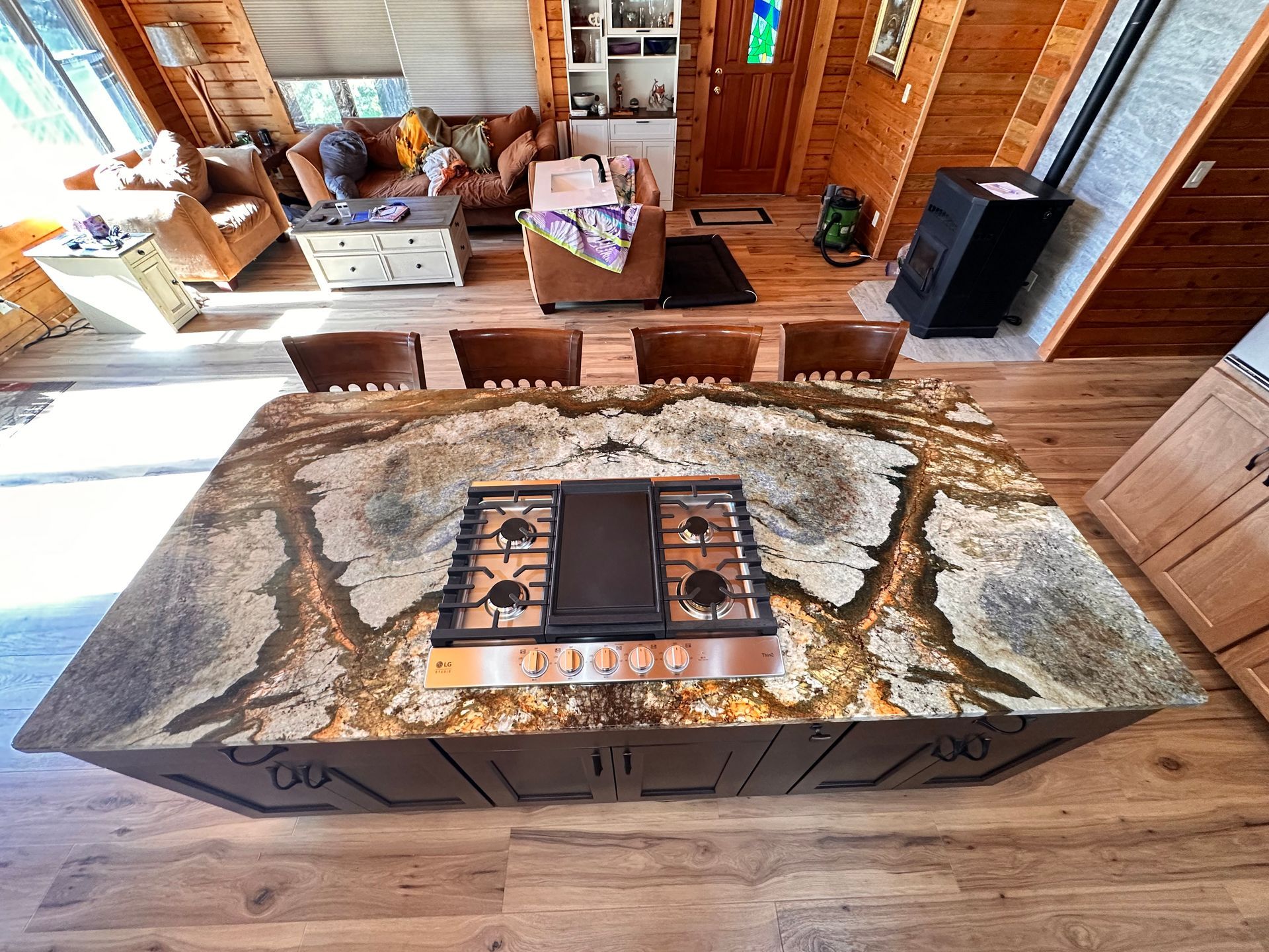 Rustic cabin dining area with a live-edge wood table and benches on a patterned rug; cozy wood-paneled interior.