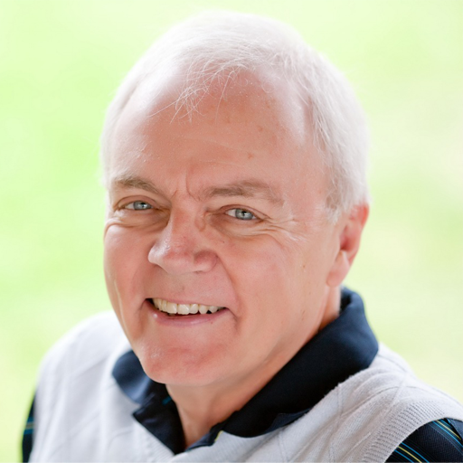 A man with white hair is smiling for the camera