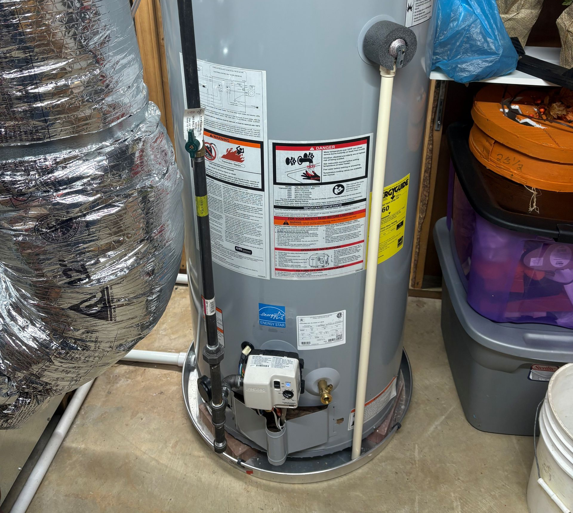 A person repairs a heating system; they are holding a tool and working on the internal components. A person repairs a heating system; they are holding a tool and working on the internal components.