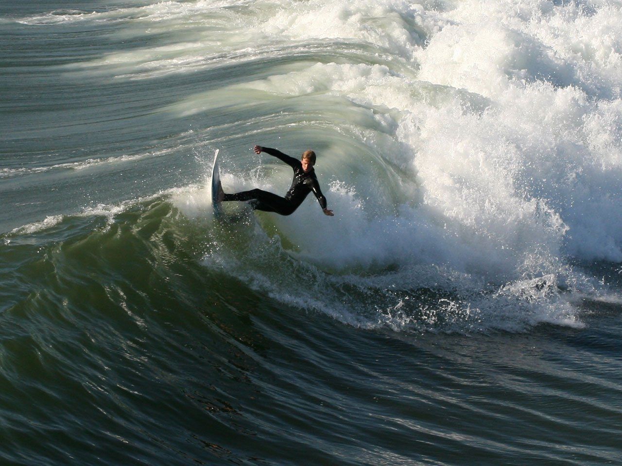 Surf Qigong in actie: een surfer die harmonie vindt op een krachtige, turquoise golf