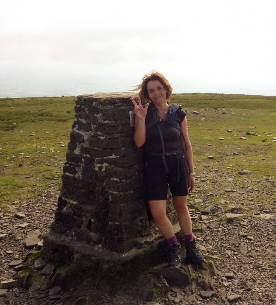 Woman standing at the top of a mountain