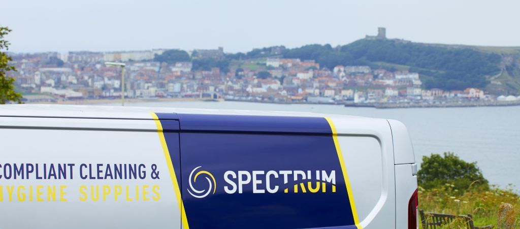 A Spectrum van is parked in front of Scarborough beach.