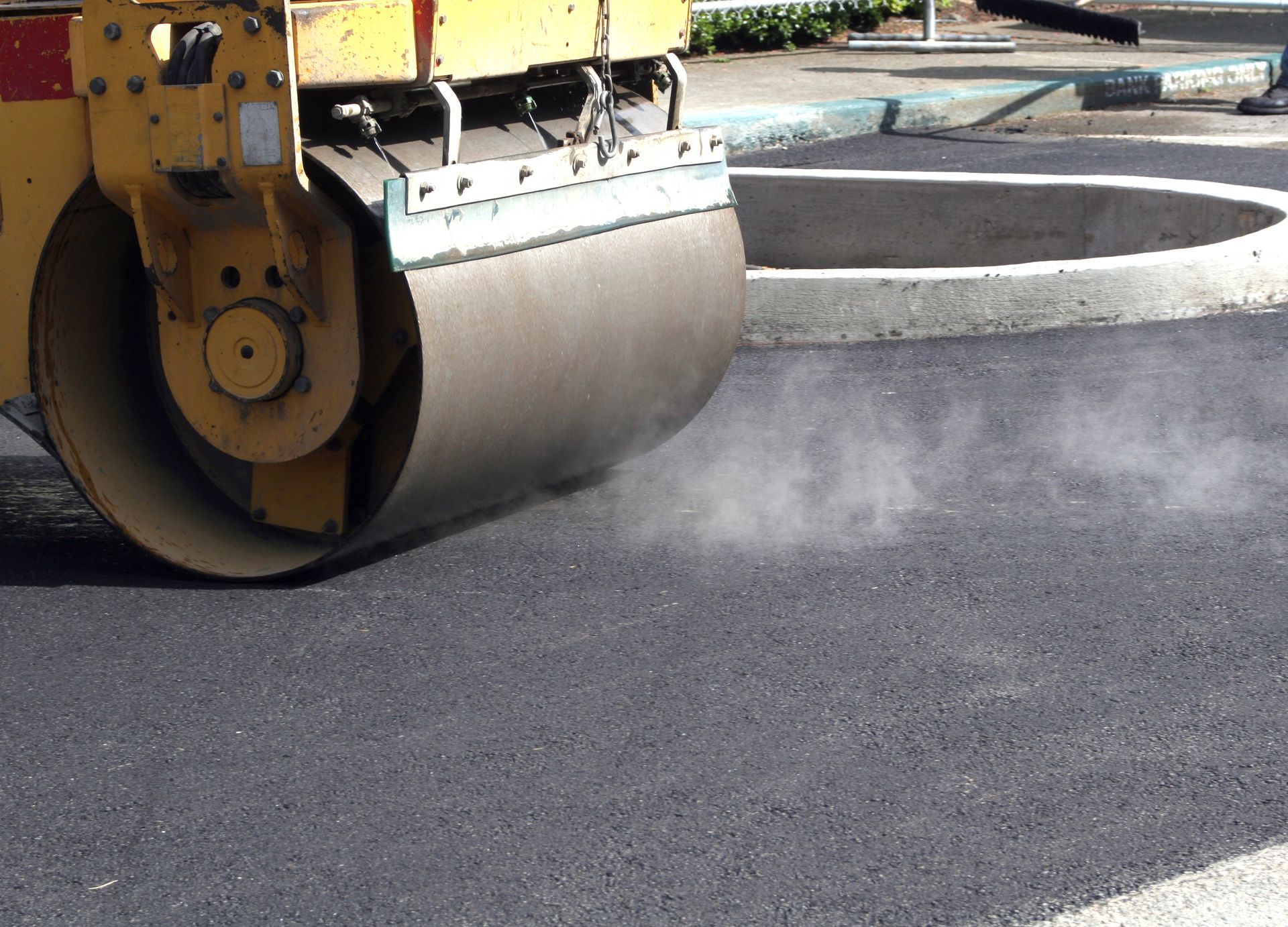 Commercial asphalt paving contractor equipment rolling new blacktop on road during construction. Commercial asphalt paving contractor equipment rolling new blacktop on road during construction.
