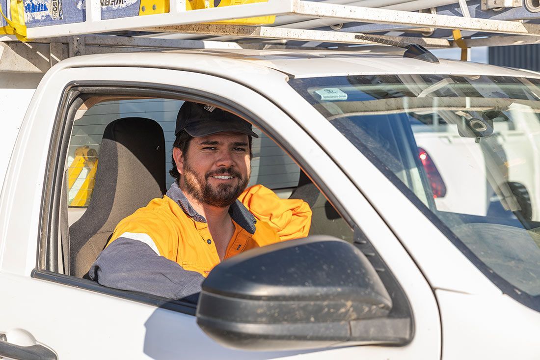 A Man is Sitting in the Driver's Seat of a White Truck — Macquarie Electric in Narromine, NSW