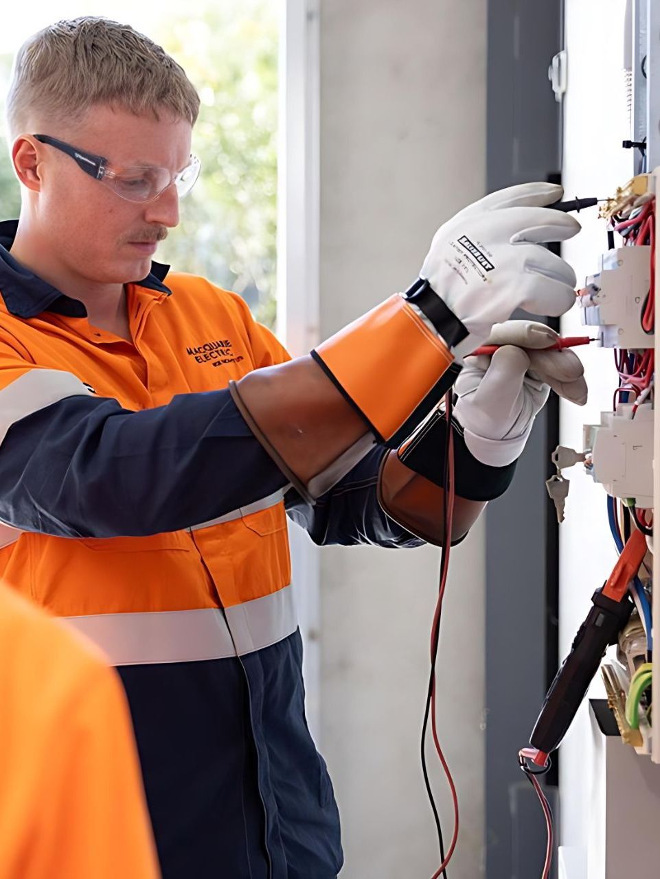 Two Men Are Sitting at a Desk Talking to Each Other — Macquarie Electric in Sydney, NSW
