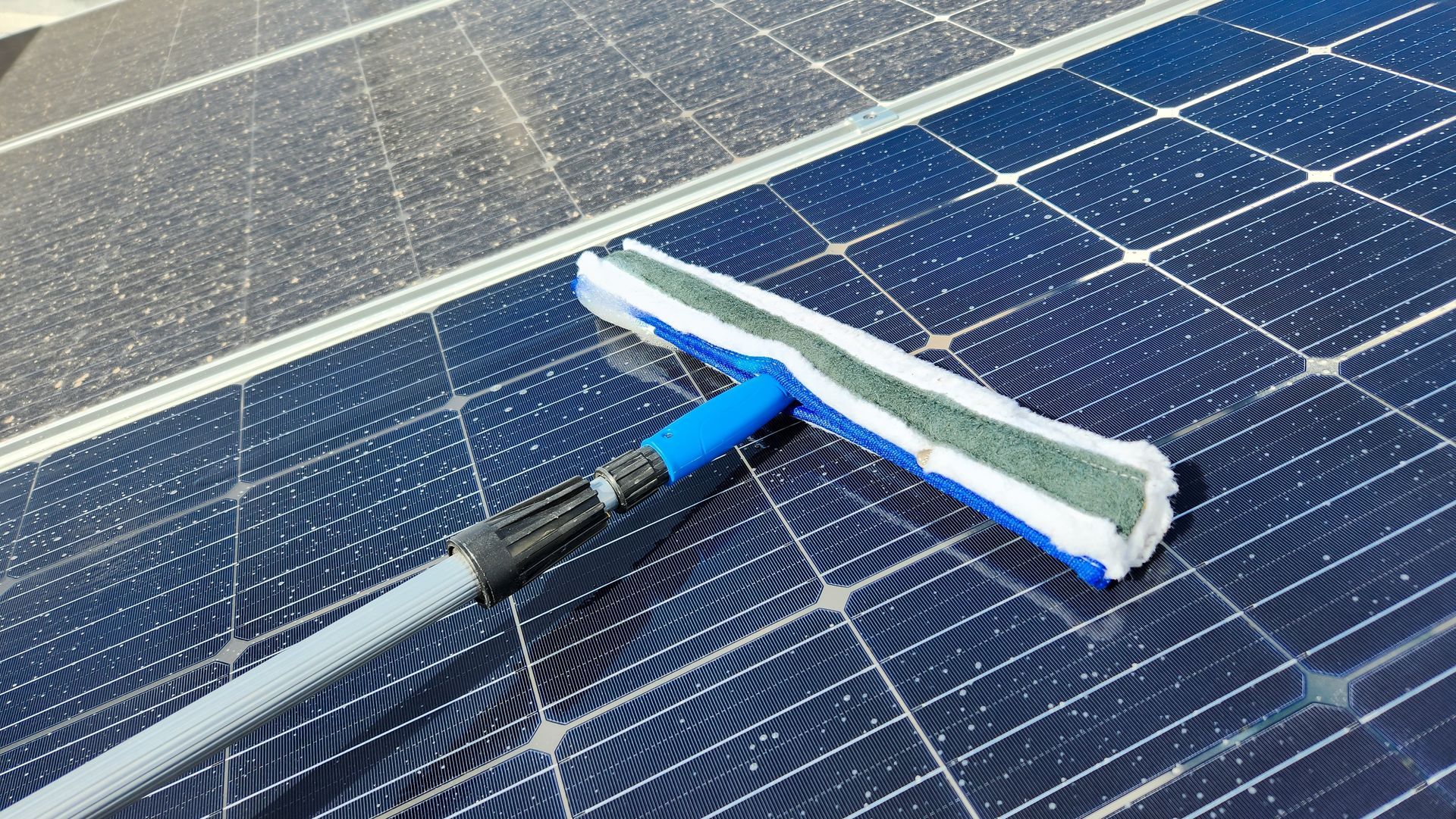 A mop is being used to clean a solar panel.