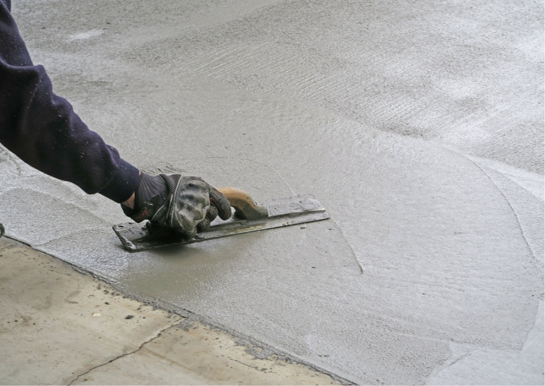 A close up of a concrete driveway with a curb.